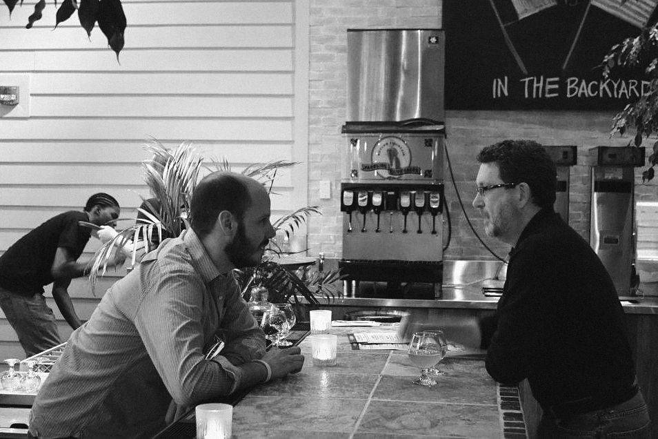 Dave talking with a guest across the bar